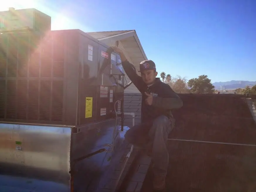 HVAC technician performing AC Tune-Up on a rooftop unit in Sandersville